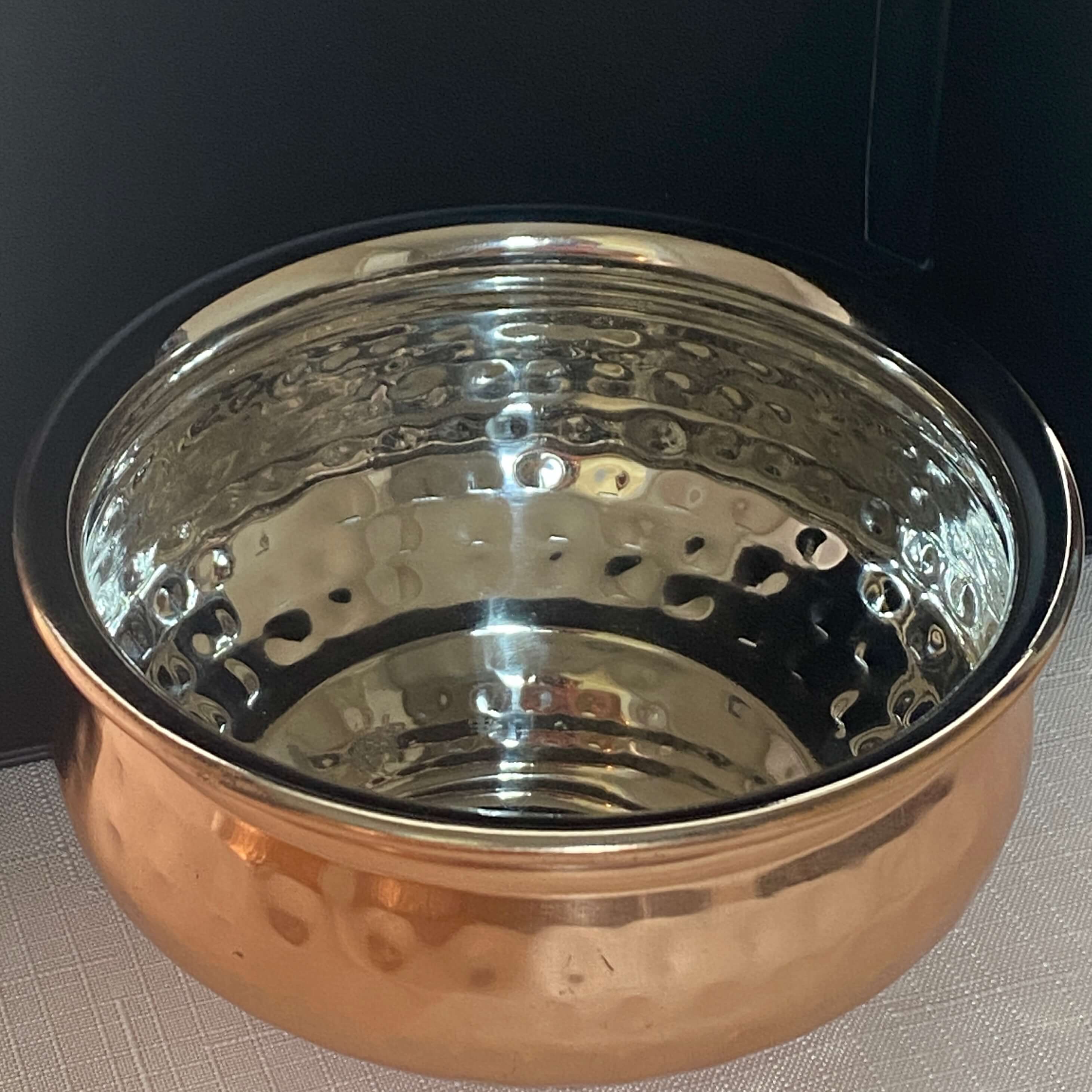 Copper and stainless snack bowl with a hammered textured finish.